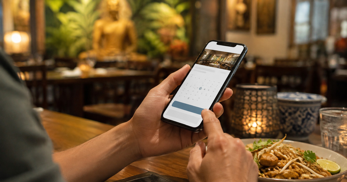 A diner making an online restaurant booking on a phone before dinner